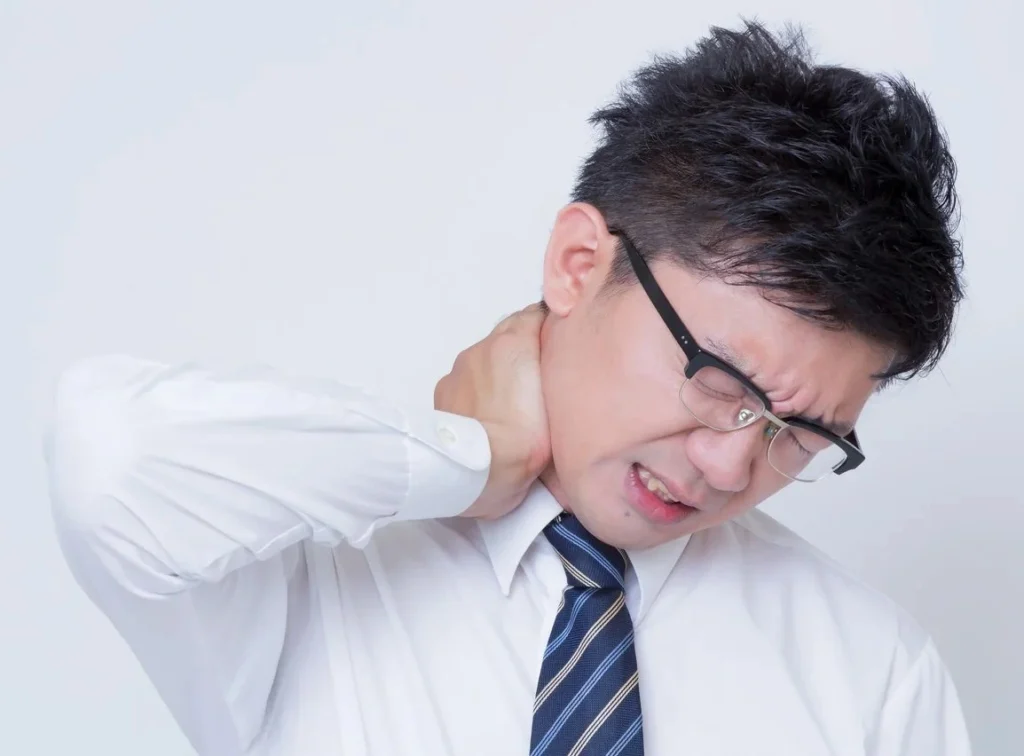 首を痛めている人の写真